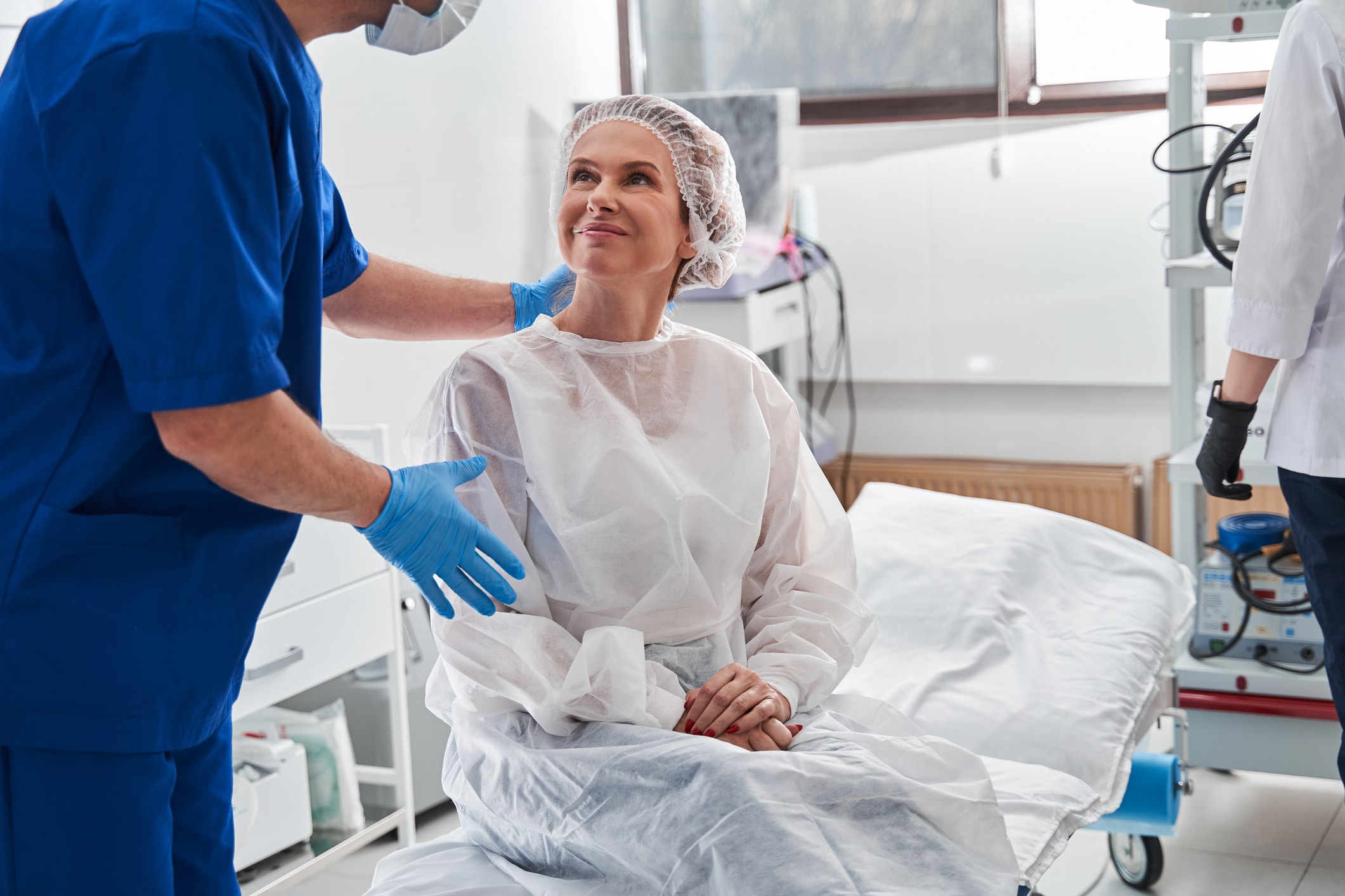 Surgery patient preparing for minimally invasive robotic surgery with surgeon.